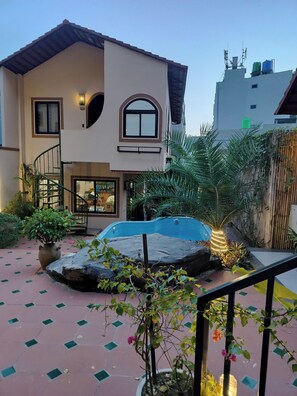 A two-story house with a swimming pool, a staircase, and a garden with plants and a rock feature. - Secret Garden Homestay  (Cat Ba island)