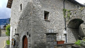 A stone building with a wooden door, a small window, and a stone archway. - El Alboroque (Tramacastilla de Tena)