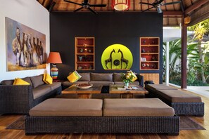 A modern living room with a sofa, coffee table, and decorative shelves. - Villa Abagram Seminyak (Seminyak)