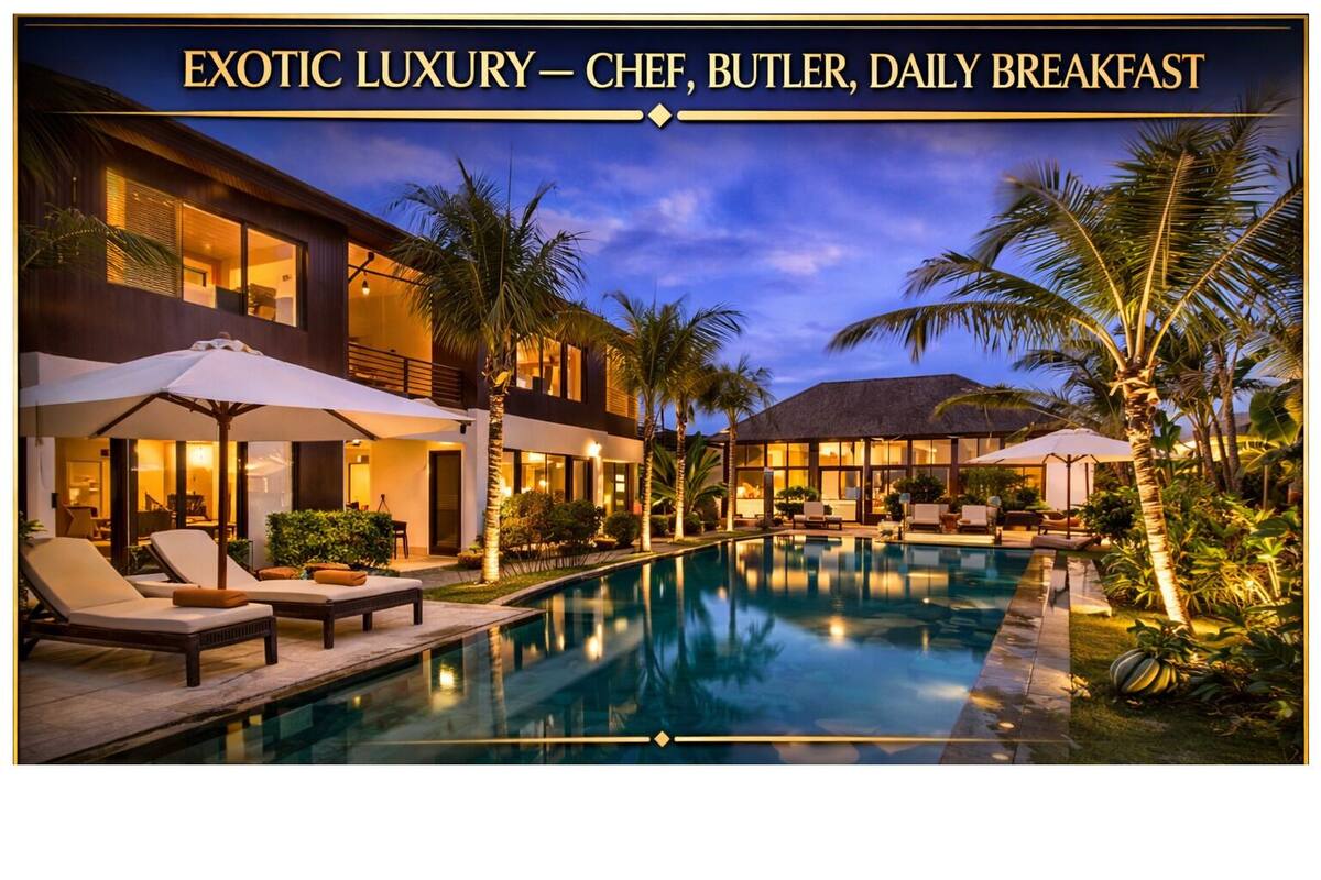 A luxurious resort with a swimming pool, sun loungers, and palm trees.