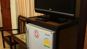 A compact kitchenette with a refrigerator, a microwave, and a flat-screen TV on top. - Trigong Residence (Chiang Mai)
