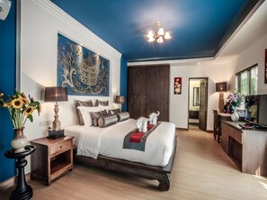 Ein Schlafzimmer mit einem großen Bett, Nachttischen, einer Kommode, einem Gemälde und einer Chandelier.