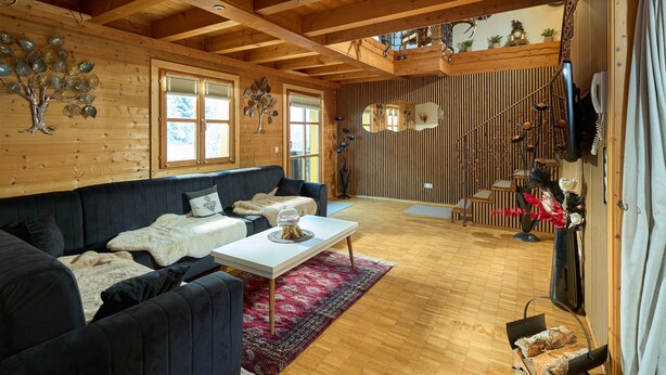 A cozy living room with a dark blue sofa, a white coffee table, and a red rug. - 1311 Alt Montafon Apartment 11 (Gaschurn)