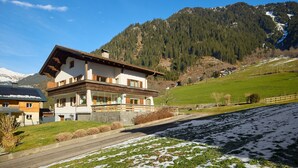 A two-story chalet with a sloped roof, wooden balcony, and a view of a mountainous landscape. - 1177 House Rosa & Alfred (Gaschurn)