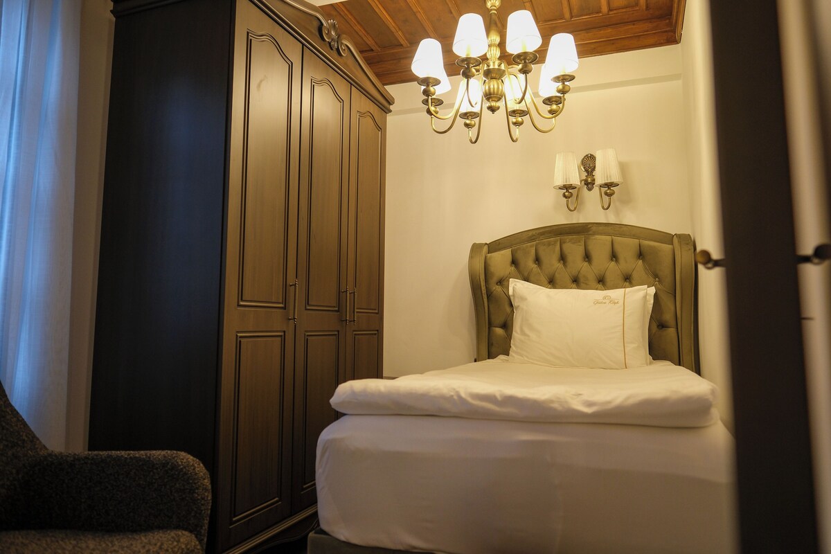 Un dormitorio con cama, armario y candelabro.