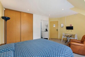 A bedroom with a bed, a wardrobe, a desk, a chair, and a television. - Apartment "Les Moulins - Studio 1" with Balcony and Wi-Fi (Cherbourg en Cotentin)