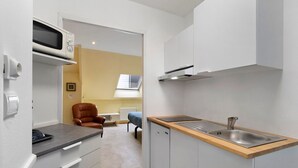 A compact kitchenette with a microwave, a sink, and a small countertop. - Apartment "Les Moulins - Studio 1" with Balcony and Wi-Fi (Cherbourg en Cotentin)