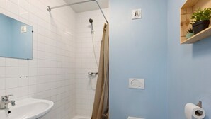 A bathroom with a shower, toilet, sink, and a towel rack. - Apartment "Les Moulins - Studio 1" with Balcony and Wi-Fi (Cherbourg en Cotentin)