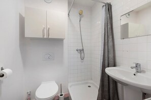 Un baño con inodoro, ducha y lavamanos.