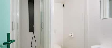 A bathroom with a shower, toilet, and sink.