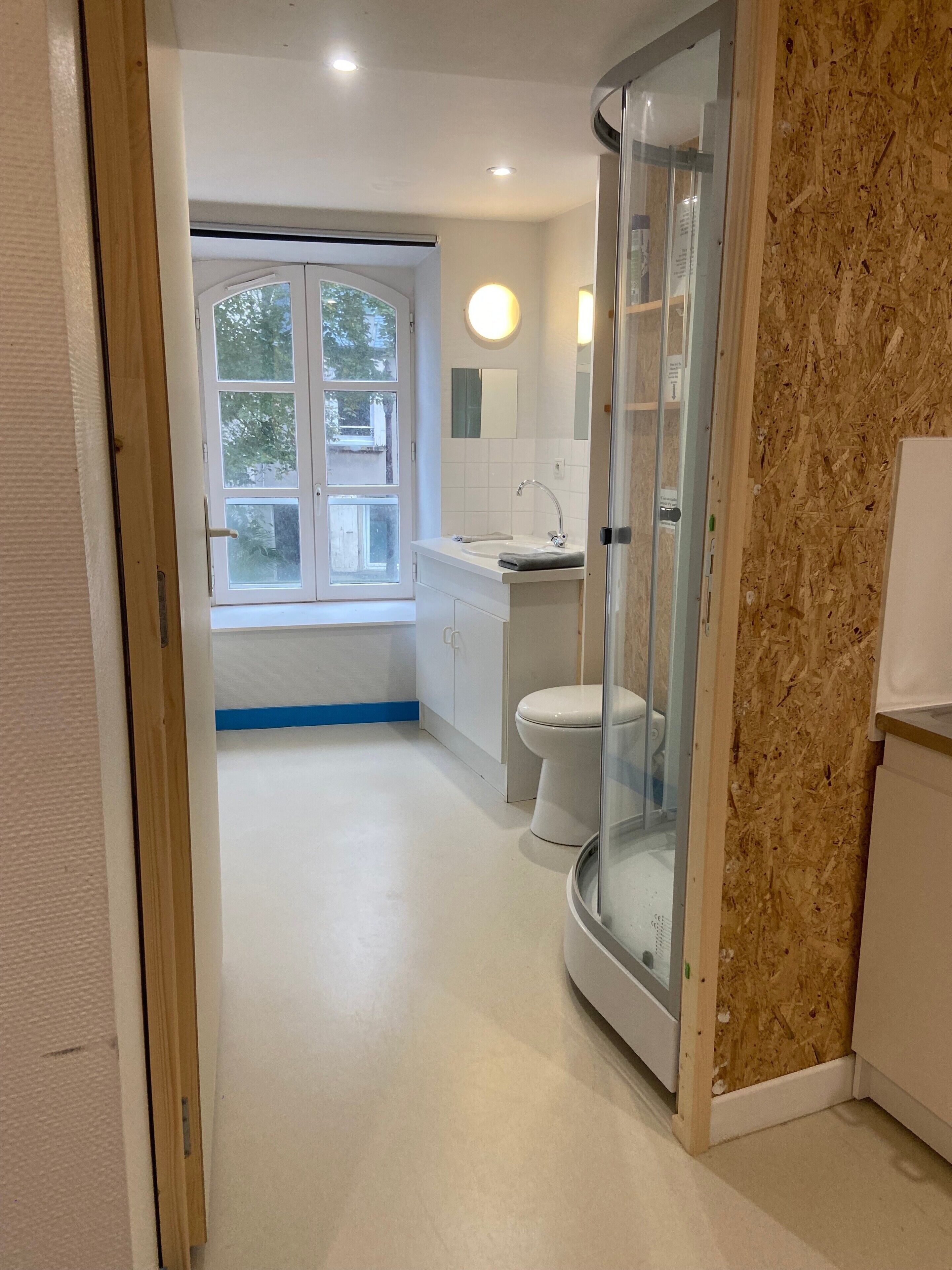 Une salle de bain avec des toilettes, un lavabo et une douche.