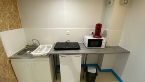 A compact kitchenette with a sink, a small refrigerator, a microwave, a toaster, and a coffee maker. - Apartment 'Les Moulins - 8' with Wi-Fi (Cherbourg en Cotentin)