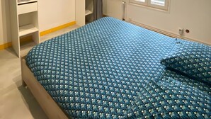 A bedroom with a bed, a wardrobe, a window, and a radiator. - Apartment 'Les Moulins - T2 - 4' with Wi-Fi (Cherbourg en Cotentin)