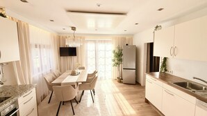 Una cocina moderna con comedor, piso de madera y un ventanal que proporciona luz natural.
