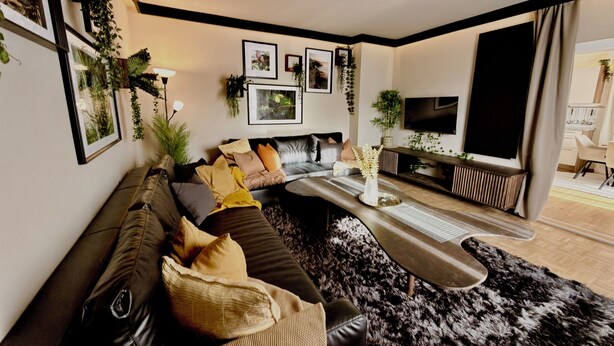 Una sala de estar moderna con sofá, mesa de centro y televisor.