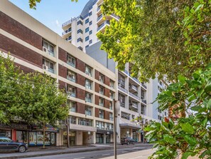 A multi-story building with a brick facade, large windows, and a flat roof. - Chic Studio With a Pool and Moments From Shop (Sydney)