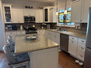 A modern kitchen with white cabinetry, a granite countertop, stainless steel appliances, and a decorative backsplash. -  5-bedroom house Ocean Grove 1.5 blocks to beach (Neptune Township)