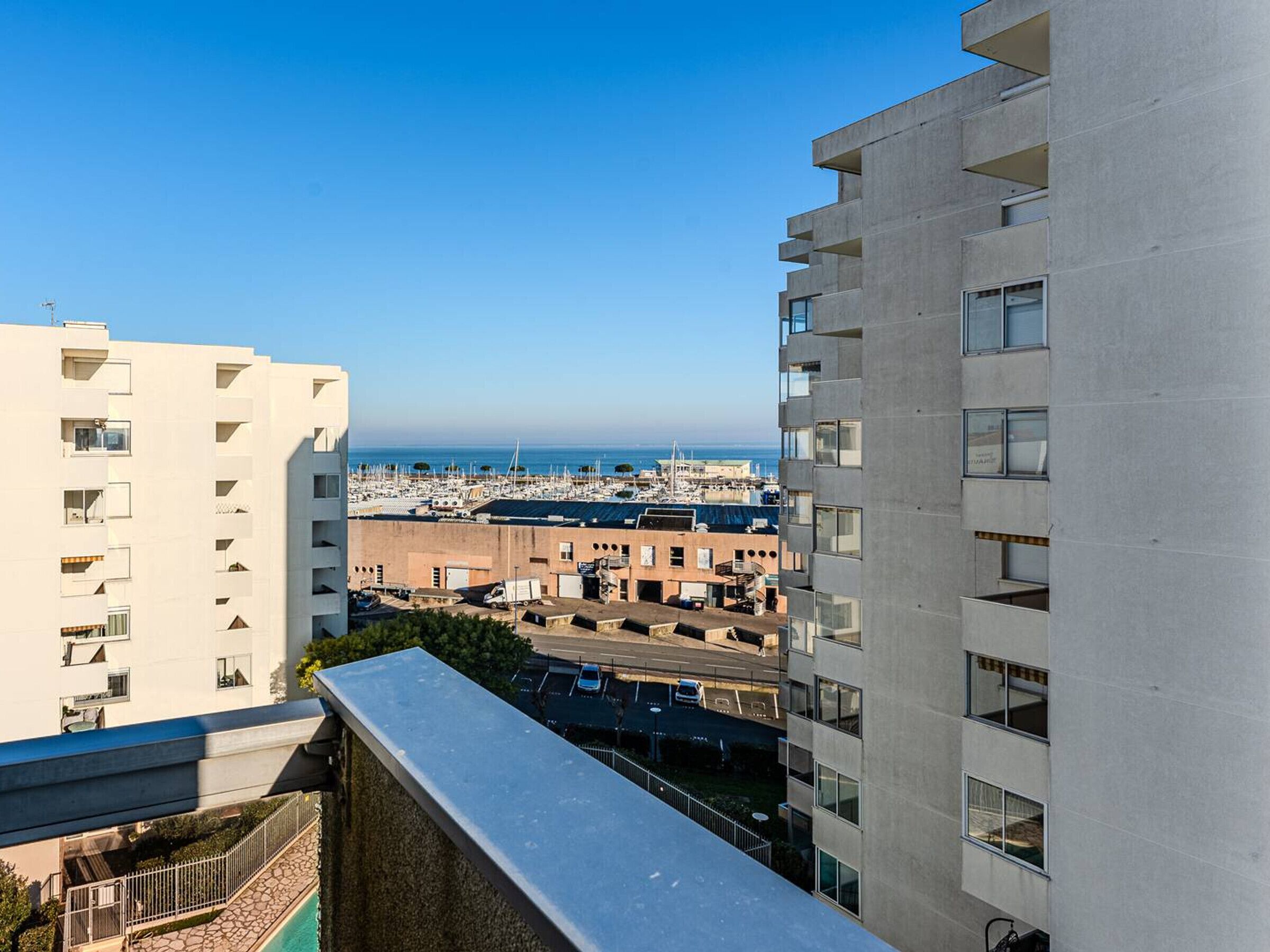 Un immeuble de grande hauteur offrant une vue sur un port de plaisance et la mer.