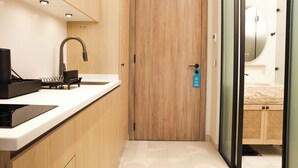A modern kitchen with a wooden door, a sink, and a built-in stove. - Inanna Resort  (Batroun)