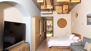A hotel room with a TV, wooden furniture, a bed, a sofa, and a small table. - Inanna Resort  (Batroun)
