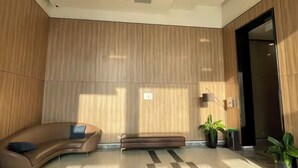 A modern lobby with a curved sofa, a bench, and potted plants. - Spacious Luxury City View with Pool - Korean Town, closed by City center & SECC (Thành phố Hồ Chí Minh)