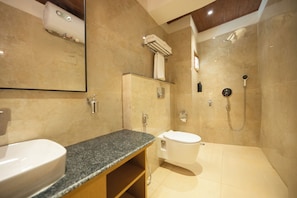 A modern bathroom with a granite countertop sink, a toilet, and a shower area. - Udaan Metho Pelri Resort (Chungthang)