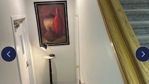Uma escada com corrimãos de madeira e tapete estampado.