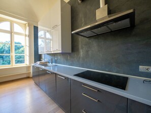 A modern kitchen with a built-in stove, a window, and a view of greenery outside. - Villa Favorita 👑 1800s King's Villa 📍Langhe&Roero - Turin 🌳Relaxation and Nature (Bra)
