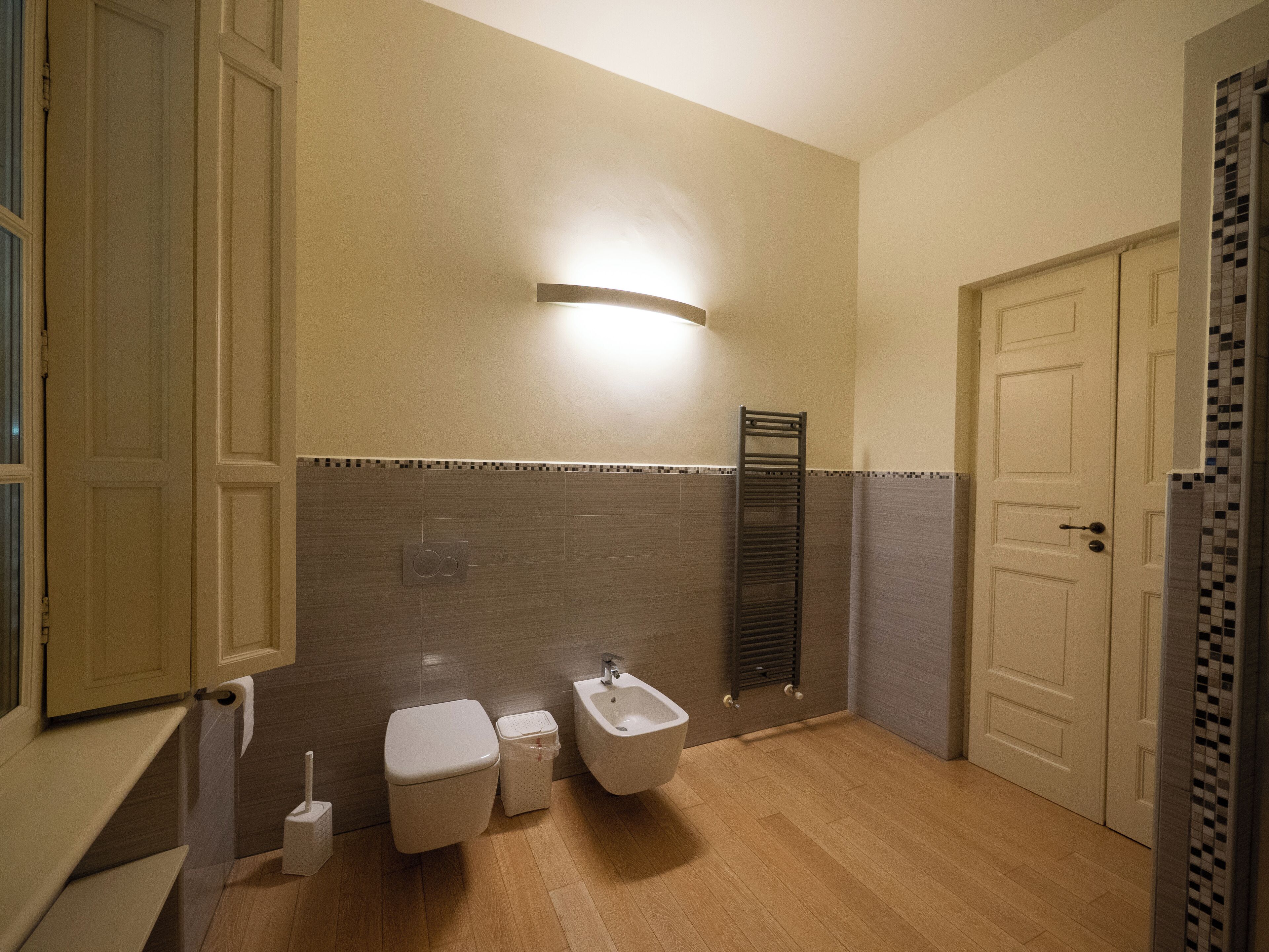 A bathroom with a toilet, bidet, and a towel rack.