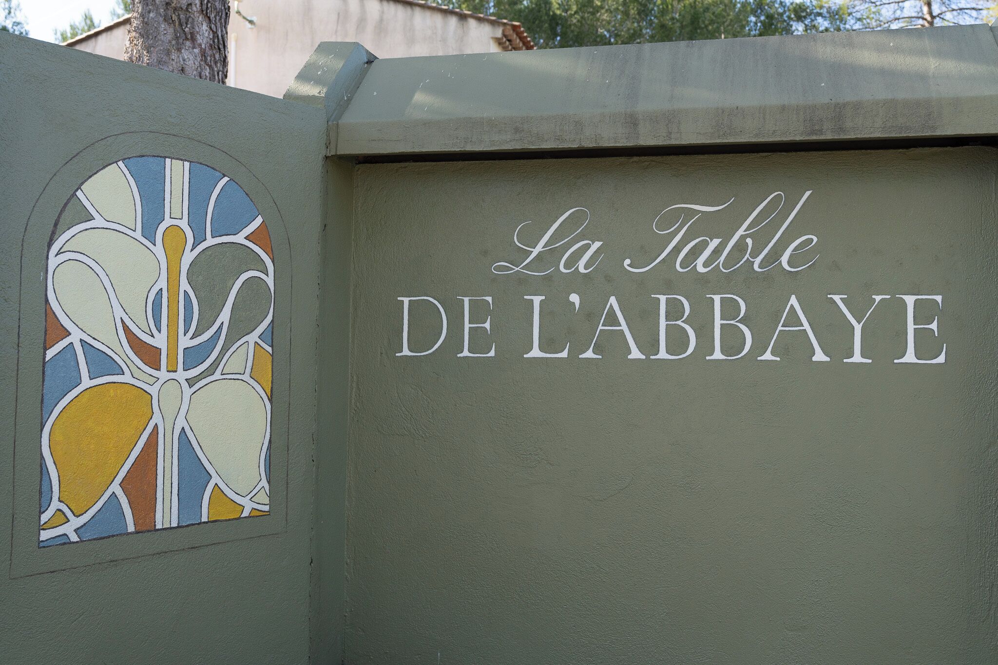 Un cartel con la inscripción 'La Table DE L'ABBAYE' en una pared.