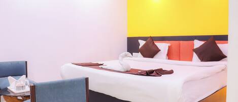 A hotel room with a bed, a chair, and a table with a tray of items.