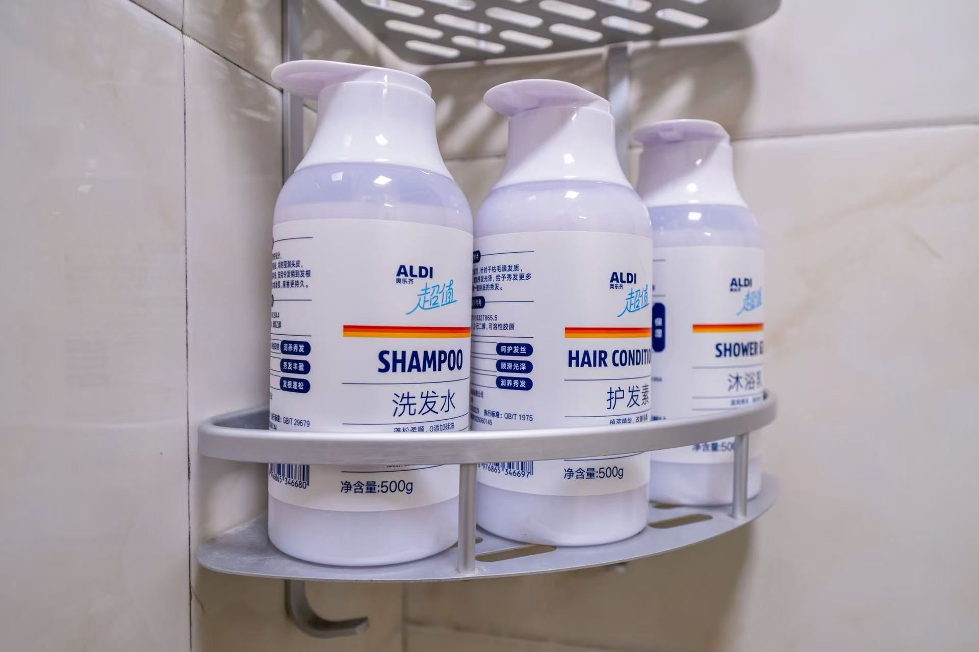 Trois bouteilles de produits pour les soins capillaires sont posées sur une étagère.