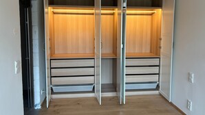 A walk-in closet with sliding doors, wooden flooring, and a light fixture. - Self-sufficient eco-house: water, electricity, internet (Solopisky)