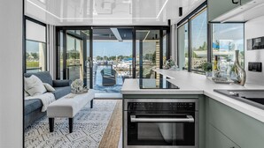 A modern kitchen with a built-in oven and a dining area with a glass-top table.