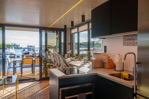 Una cocina moderna con vistas a un puerto deportivo, equipada con un lavamanos, estufa y varios electrodomésticos de cocina.