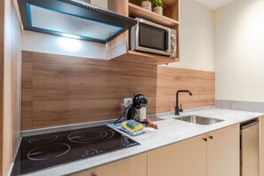 Een moderne keuken met een inbouwmagnetron, een fornuis en een spoelbak.