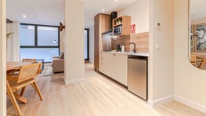 Une cuisine moderne avec des meubles en bois, un four à micro-ondes encastré et un lave-vaisselle.