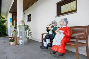 Un banc amb dues estàtues de persones assegudes.
