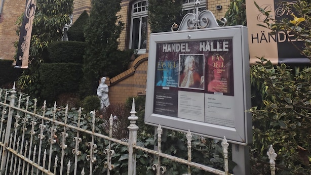 En klassisk byggnad med en skylt som visar texten ”HANDEL HALLE” och ”BACH”.