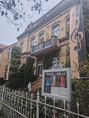 Un bâtiment de style classique, sur lequel on peut lire les inscriptions « HANDEL HALLE » et « BACH ».