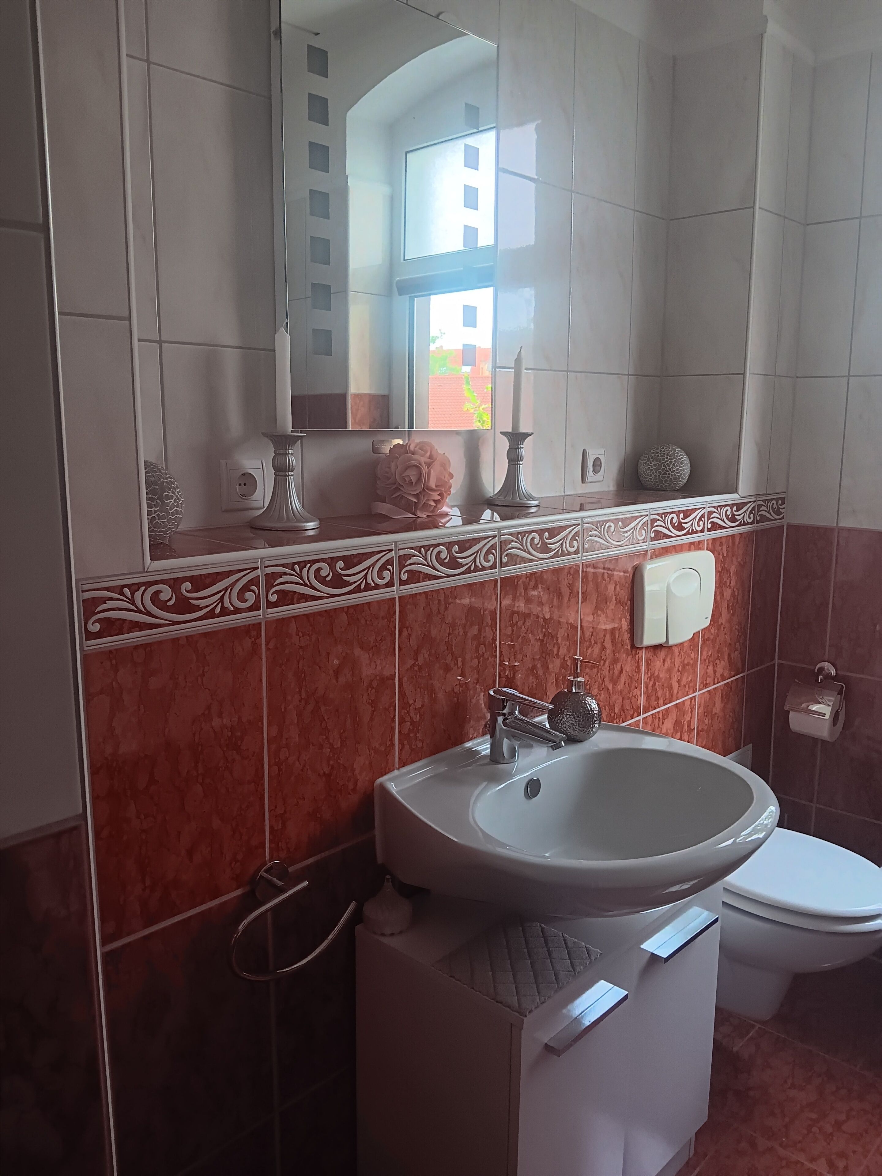 Une salle de bain avec un lavabo, des toilettes et un miroir.