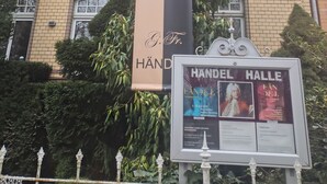 En byggnad med en stor banderoll som visar en g-klav och ordet ”HANDEL”.