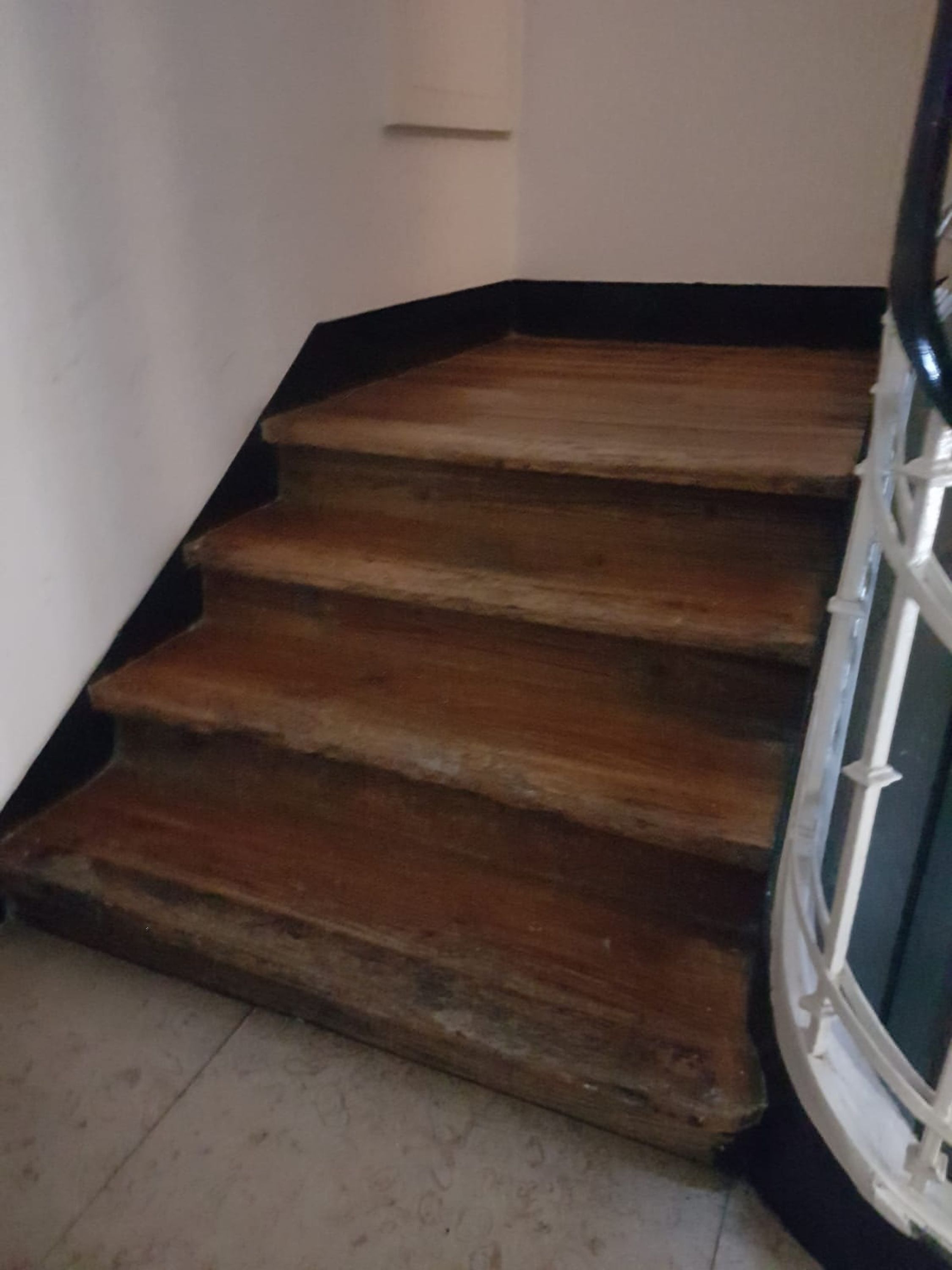 Un escalier avec des marches en bois et une rampe blanche.
