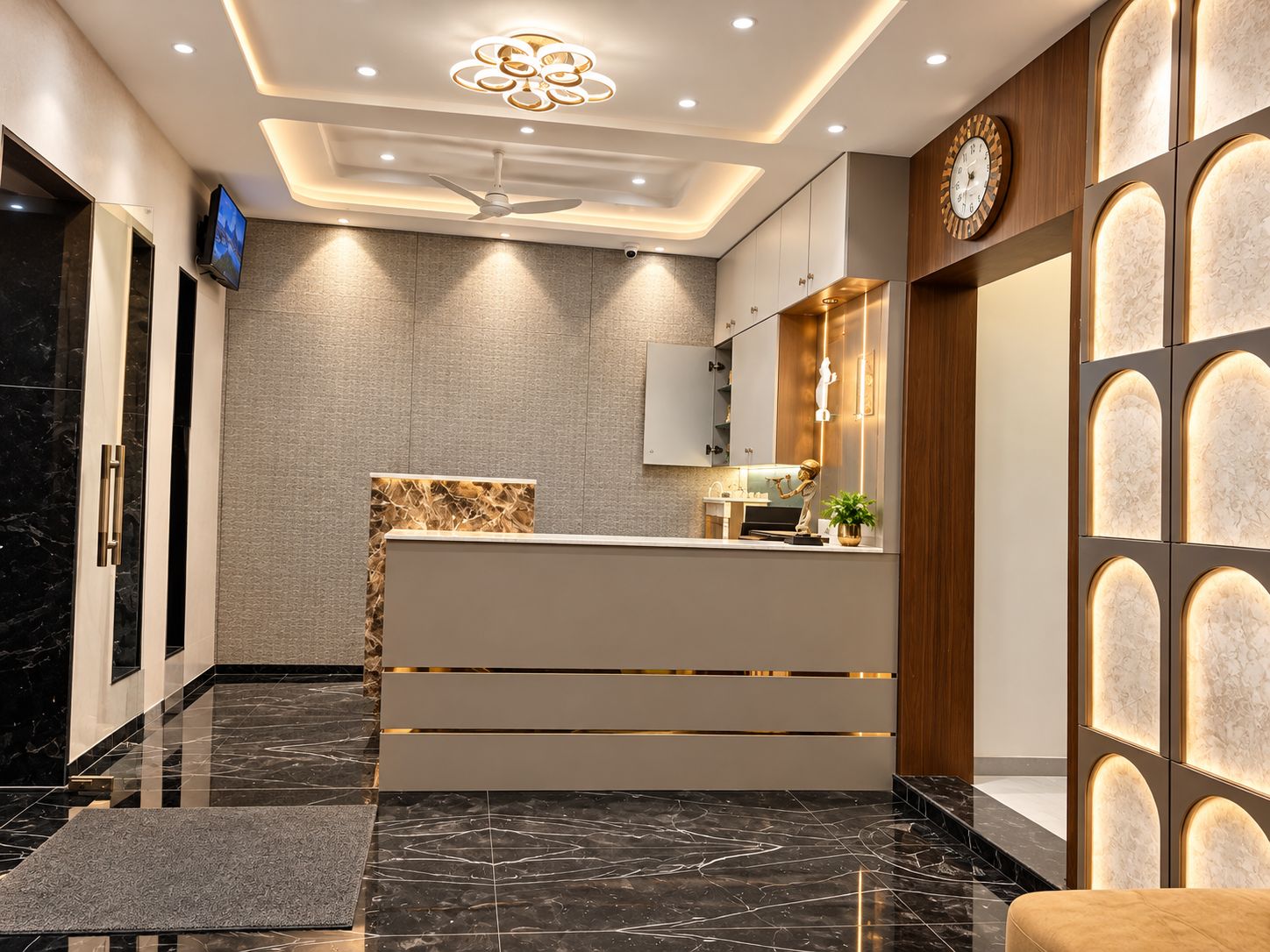 Un área de recepción moderna con piso de mármol, un mostrador de recepción, un reloj en la pared y un ventilador de techo.