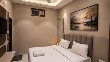 Un dormitorio moderno con cama, mesita de noche y ventilador de techo.