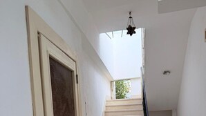 Un escalier menant à un balcon d’où l’on peut admirer la verdure.