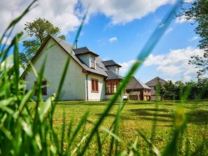 A house with a sloped roof, a chimney, and a well-maintained lawn. - Holly House (Blairgowrie)