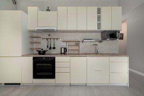 A modern kitchen with white cabinetry, a built-in oven, and a microwave. - Stylish Studio with a Balcony | 1.3 km from the Market Square (Wrocław)