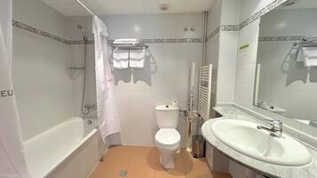 Un baño con bañera, inodoro y lavabo.