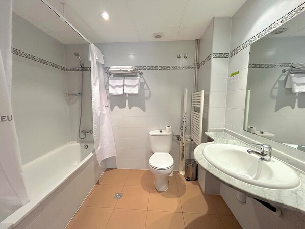 Un baño con bañera, inodoro y lavabo.